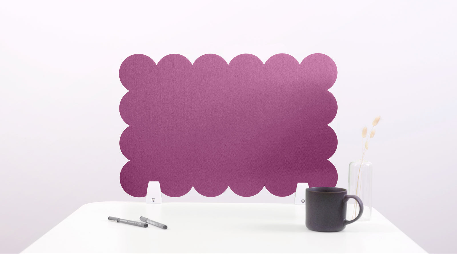 Purple scalloped headboard on a white background with a black mug and pen.