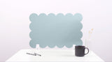 Light blue scalloped headboard on a white background with a black mug and pen.