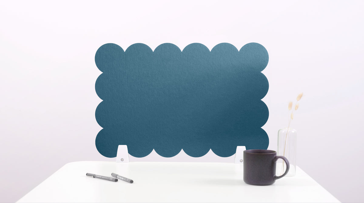 Blue scalloped screen on a white surface with a black mug and pen.