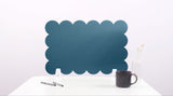 Blue scalloped screen on a white surface with a black mug and pen.