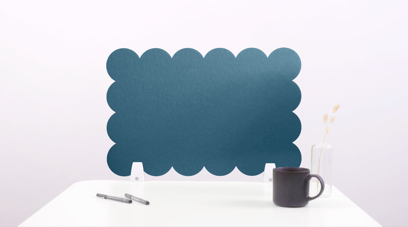 Blue scalloped screen on a white surface with a black mug and pen.