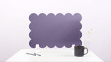 Purple scalloped headboard on a white background with a black mug and pen.