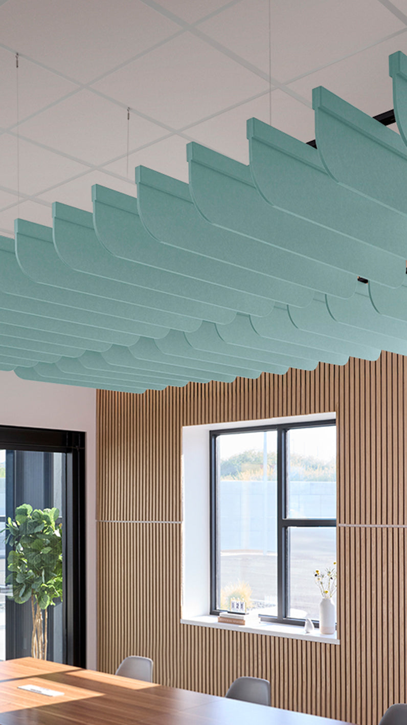 Baby blue acoustic ceiling blade baffles suspended from the ceiling, installed in a conference room. Felt Right's acoustic blade baffles absorb 65% of sound waves, making office spaces quieter and feel more calm.