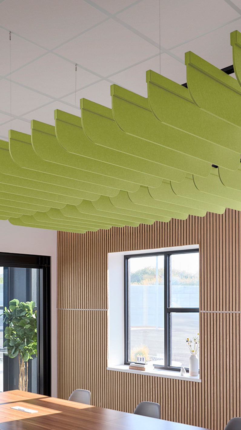 Lime green acoustic ceiling blade baffles suspended from the ceiling, installed in a conference room. Felt Right's acoustic blade baffles absorb 65% of sound waves, making office spaces quieter and feel more calm.