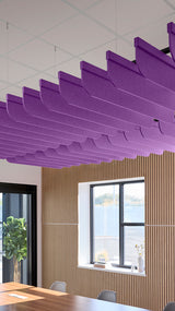 Purple acoustic ceiling blade baffles suspended from the ceiling, installed in a conference room. Felt Right's acoustic blade baffles absorb 65% of sound waves, making office spaces quieter and feel more calm.