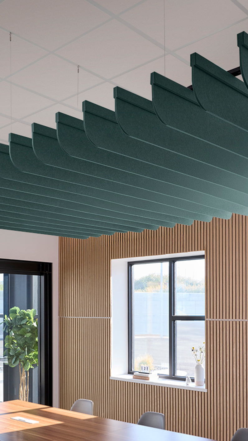 Blue-green acoustic ceiling blade baffles suspended from the ceiling, installed in a conference room. Felt Right's acoustic blade baffles absorb 65% of sound waves, making office spaces quieter and feel more calm.