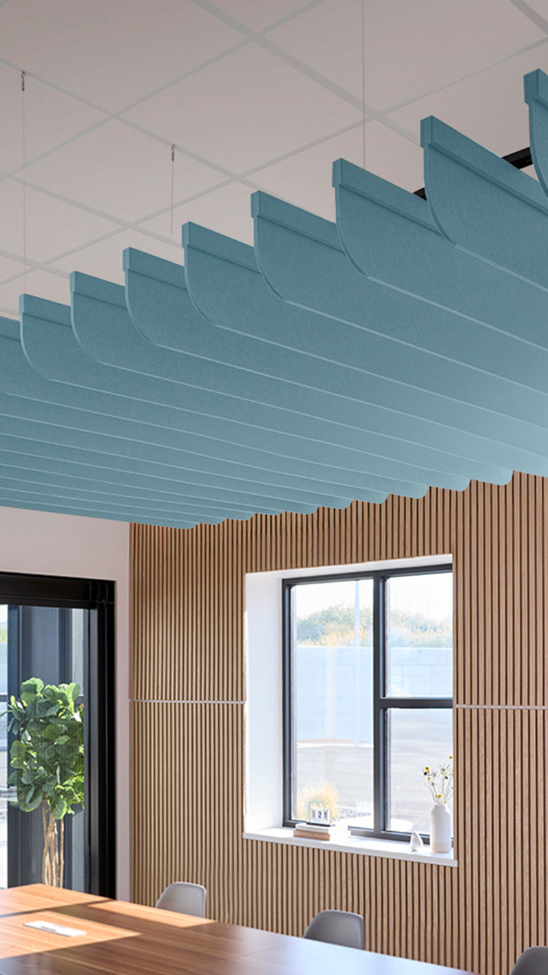 Baby blue acoustic ceiling blade baffles suspended from the ceiling, installed in a conference room. Felt Right's acoustic blade baffles absorb 65% of sound waves, making office spaces quieter and feel more calm.
