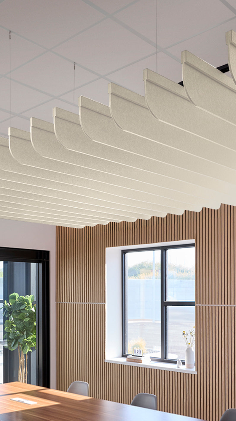 Cream acoustic ceiling blade baffles suspended from the ceiling, installed in a conference room. Felt Right's acoustic blade baffles absorb 65% of sound waves, making office spaces quieter and feel more calm.