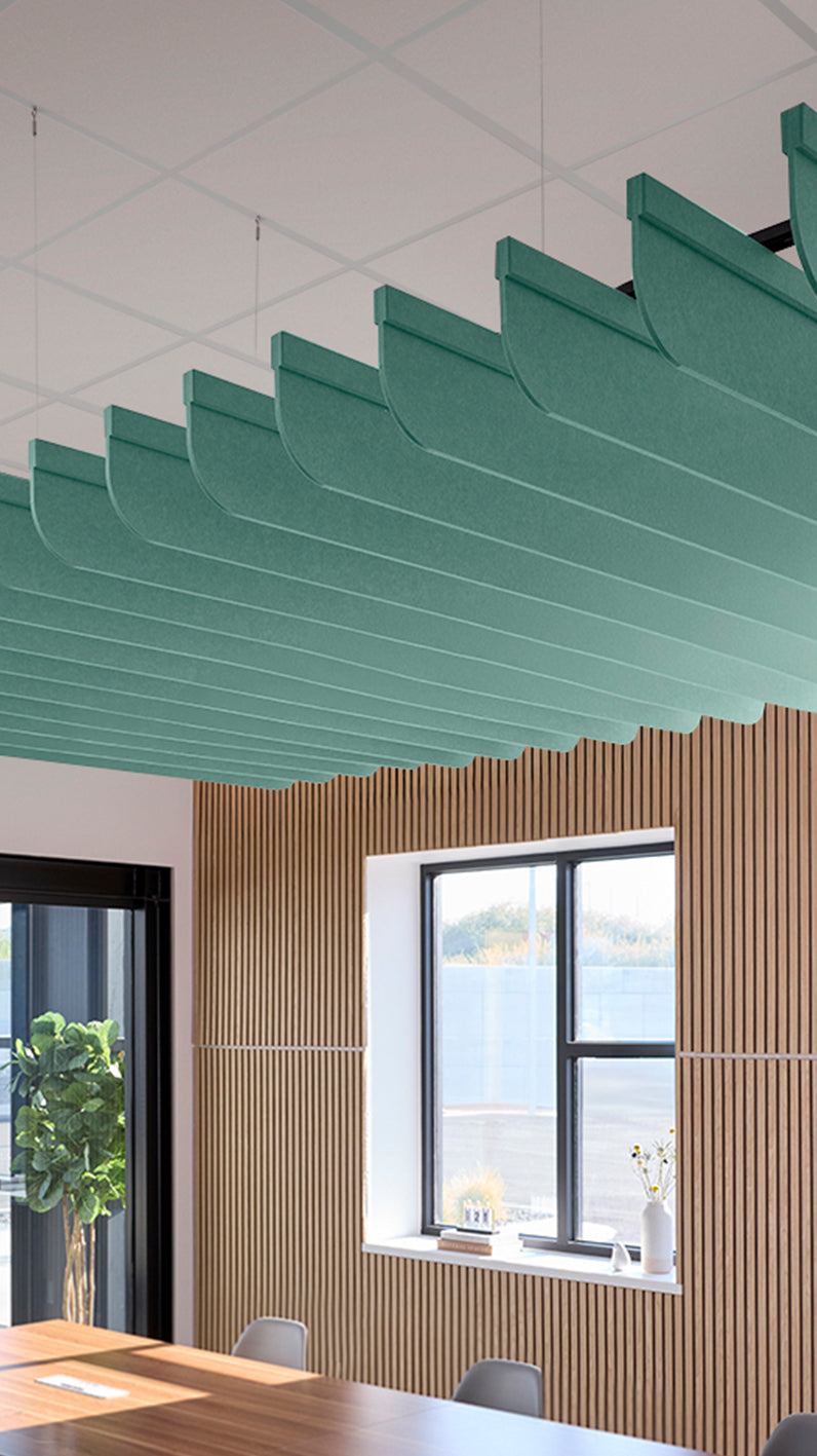 Mint green acoustic ceiling blade baffles suspended from the ceiling, installed in a conference room. Felt Right's acoustic blade baffles absorb 65% of sound waves, making office spaces quieter and feel more calm.