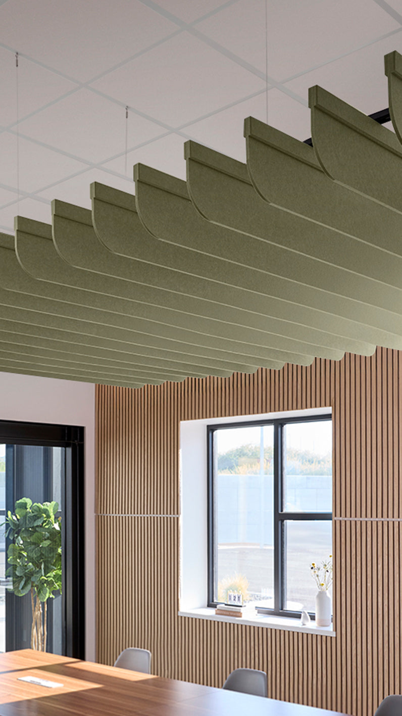 Green acoustic ceiling blade baffles suspended from the ceiling, installed in a conference room. Felt Right's acoustic blade baffles absorb 65% of sound waves, making office spaces quieter and feel more calm.