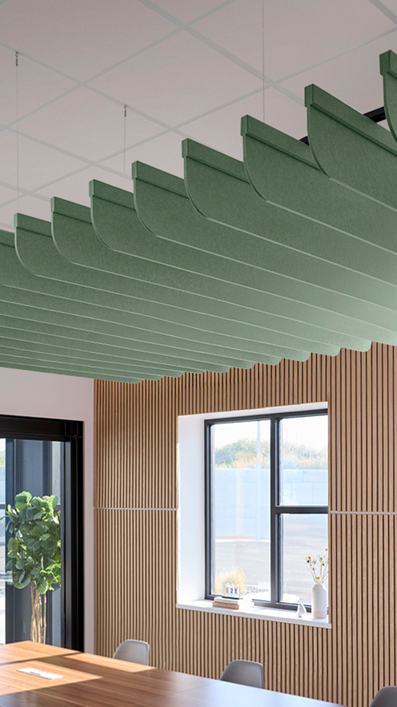 Green acoustic ceiling blade baffles suspended from the ceiling, installed in a conference room. Felt Right's acoustic blade baffles absorb 65% of sound waves, making office spaces quieter and feel more calm.