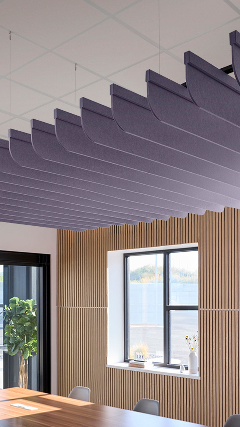 Soft violet acoustic ceiling blade baffles suspended from the ceiling, installed in a conference room. Felt Right's acoustic blade baffles absorb 65% of sound waves, making office spaces quieter and feel more calm.