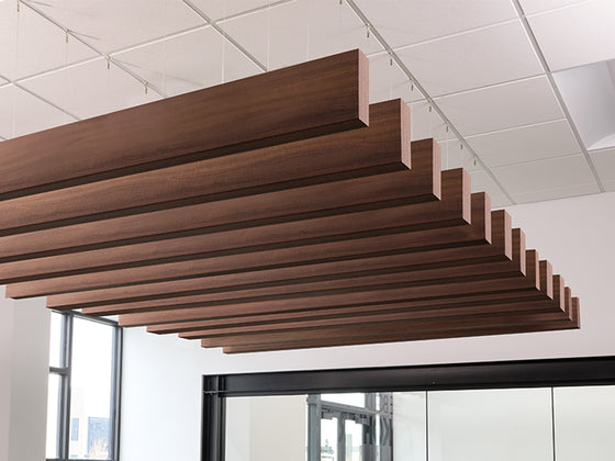 Felt Right Walnut Wood Grain Acoustic Ceiling beams in a conference room with an acoustic ceiling tile grid above the suspended beams.