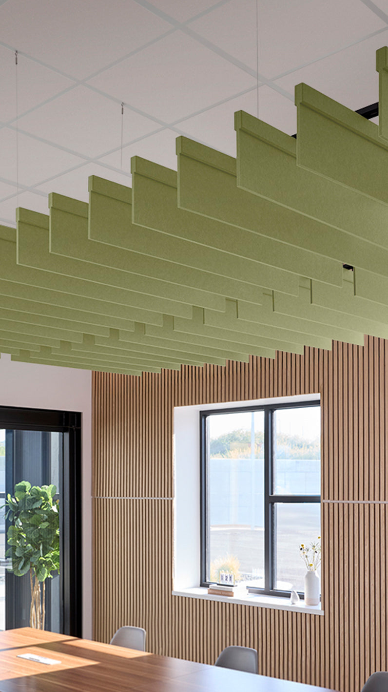 Light green acoustic ceiling blade baffles suspended from the ceiling, installed in a conference room. Felt Right's acoustic blade baffles absorb 65% of sound waves, making office spaces quieter and feel more calm.