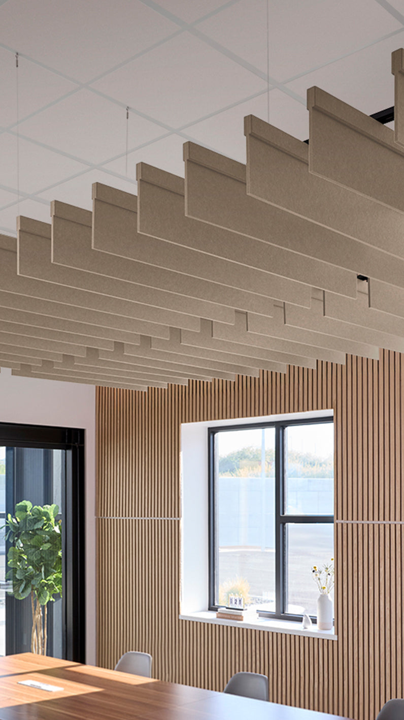 Creamy beige acoustic ceiling blade baffles suspended from the ceiling, installed in a conference room. Felt Right's acoustic blade baffles absorb 65% of sound waves, making office spaces quieter and feel more calm.