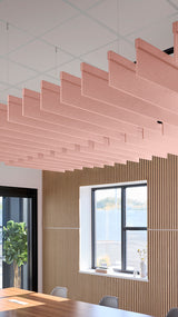 Soft pink acoustic ceiling blade baffles suspended from the ceiling, installed in a conference room. Felt Right's acoustic blade baffles absorb 65% of sound waves, making office spaces quieter and feel more calm.