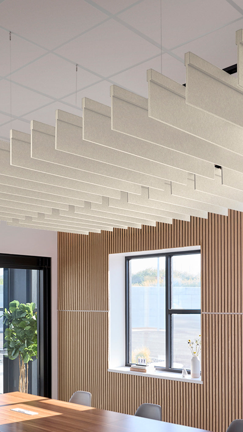 Cream acoustic ceiling blade baffles suspended from the ceiling, installed in a conference room. Felt Right's acoustic blade baffles absorb 65% of sound waves, making office spaces quieter and feel more calm.