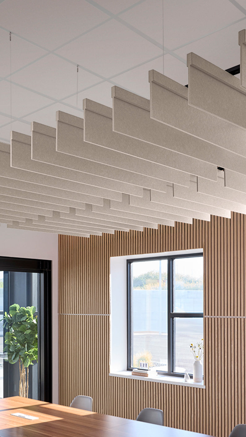 Light grey-brown acoustic ceiling blade baffles suspended from the ceiling, installed in a conference room. Felt Right's acoustic blade baffles absorb 65% of sound waves, making office spaces quieter and feel more calm.