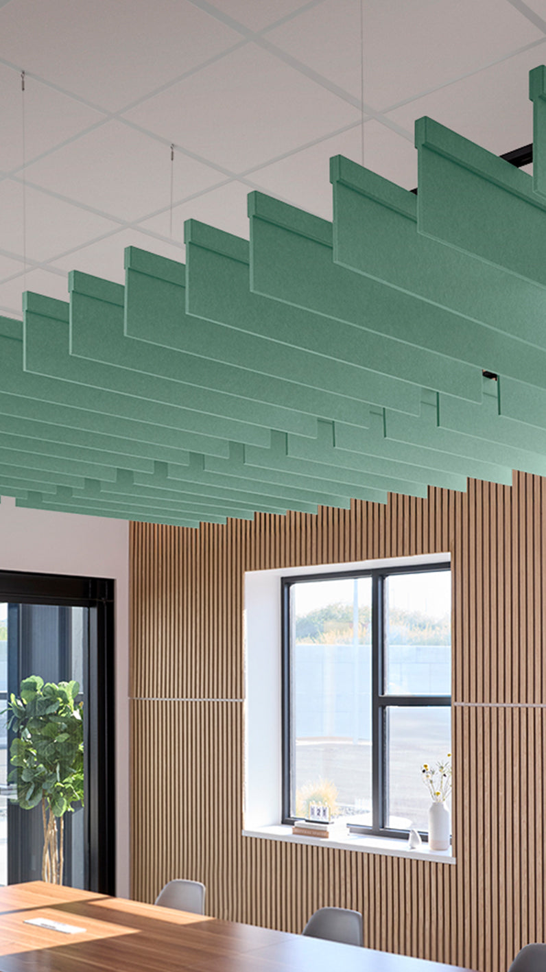 Mint green acoustic ceiling blade baffles suspended from the ceiling, installed in a conference room. Felt Right's acoustic blade baffles absorb 65% of sound waves, making office spaces quieter and feel more calm.