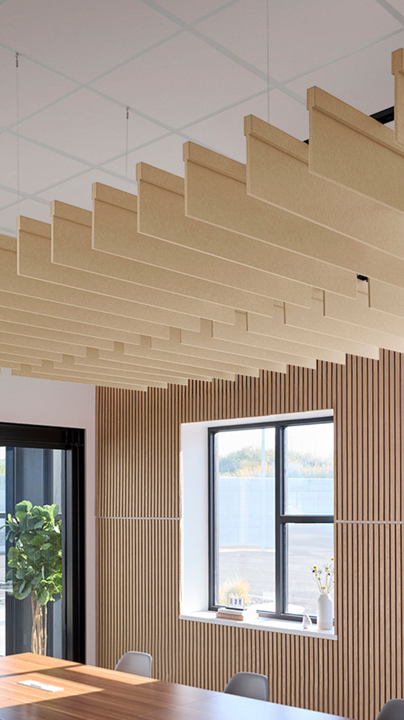 Light tan acoustic ceiling blade baffles suspended from the ceiling, installed in a conference room. Felt Right's acoustic blade baffles absorb 65% of sound waves, making office spaces quieter and feel more calm.