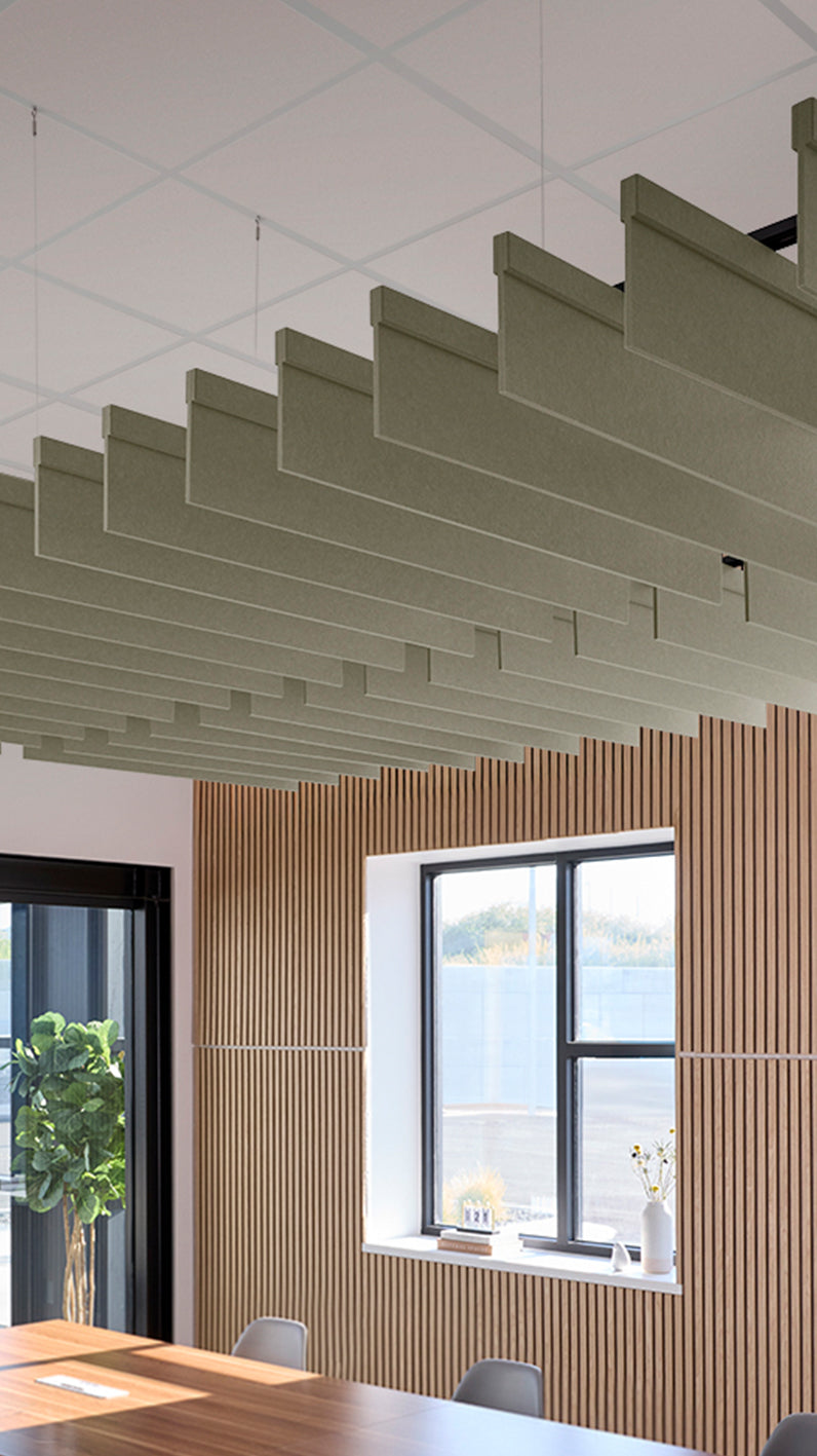Soft green acoustic ceiling blade baffles suspended from the ceiling, installed in a conference room. Felt Right's acoustic blade baffles absorb 65% of sound waves, making office spaces quieter and feel more calm.