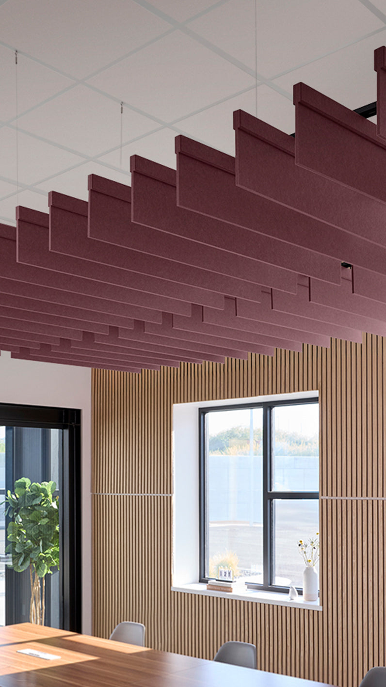 Deep reddish-purple acoustic ceiling blade baffles suspended from the ceiling, installed in a conference room. Felt Right's acoustic blade baffles absorb 65% of sound waves, making office spaces quieter and feel more calm.