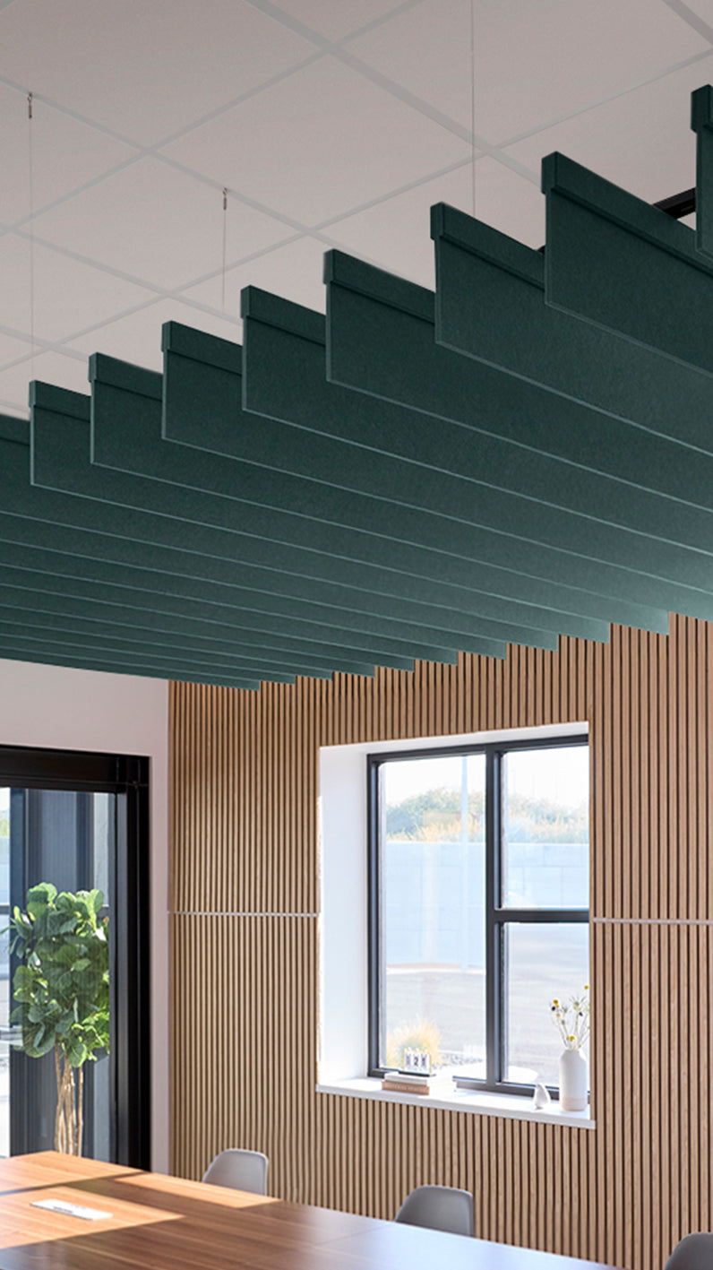 Blue-green acoustic ceiling blade baffles suspended from the ceiling, installed in a conference room. Felt Right's acoustic blade baffles absorb 65% of sound waves, making office spaces quieter and feel more calm.