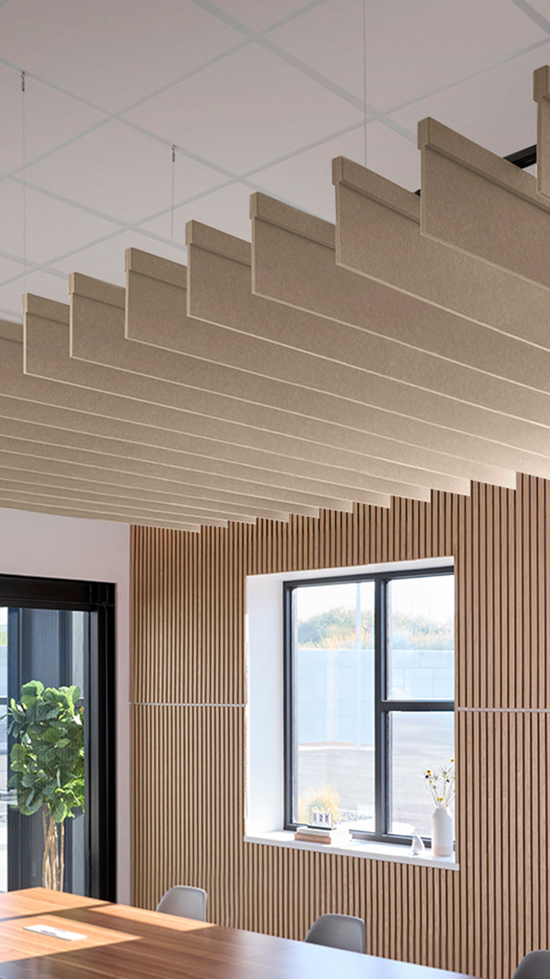 Creamy beige acoustic ceiling blade baffles suspended from the ceiling, installed in a conference room. Felt Right's acoustic blade baffles absorb 65% of sound waves, making office spaces quieter and feel more calm.