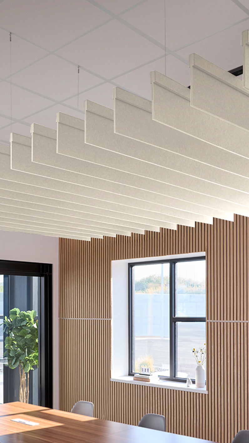 Cream acoustic ceiling blade baffles suspended from the ceiling, installed in a conference room. Felt Right's acoustic blade baffles absorb 65% of sound waves, making office spaces quieter and feel more calm.