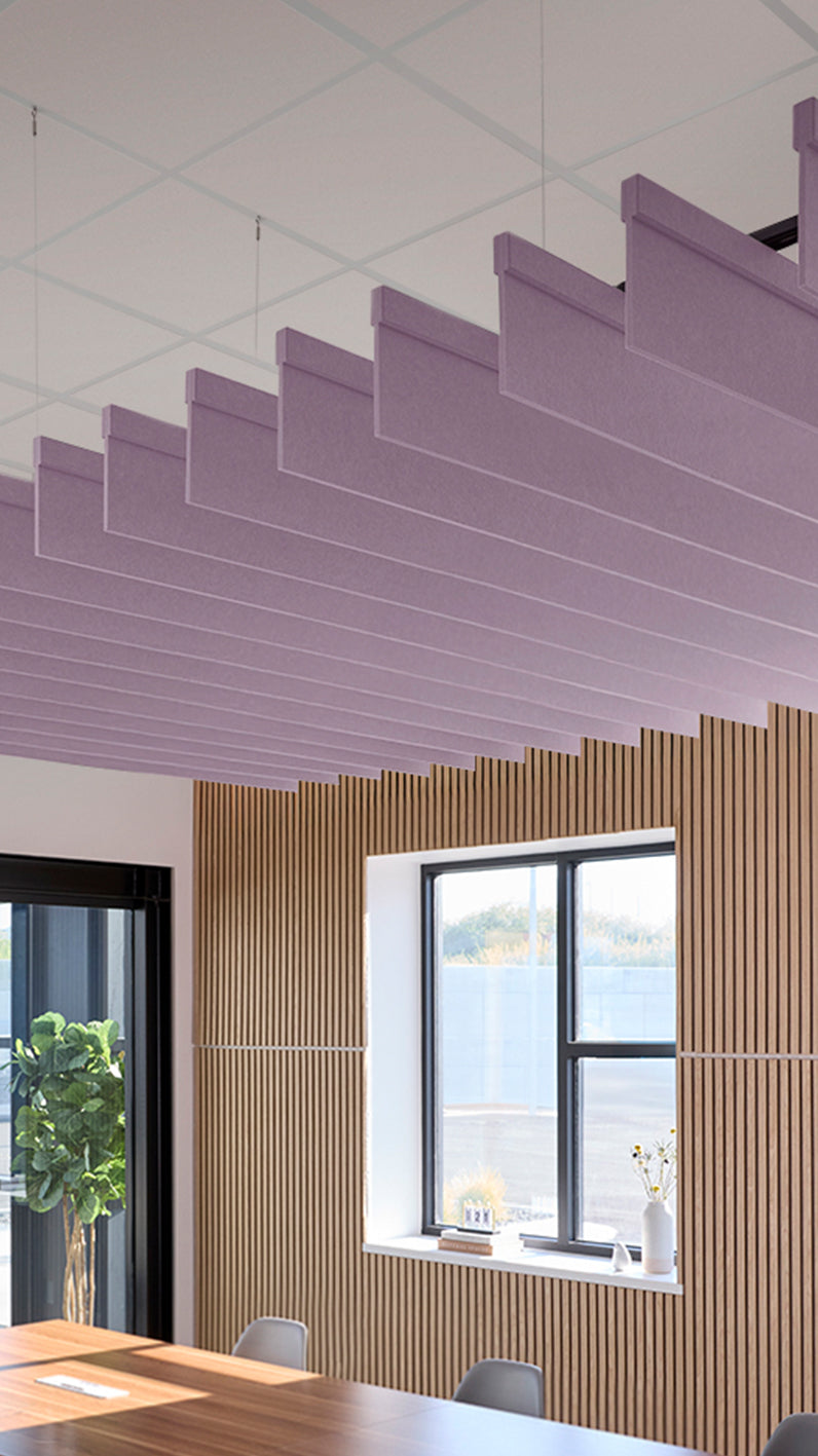 Light purple acoustic ceiling blade baffles suspended from the ceiling, installed in a conference room. Felt Right's acoustic blade baffles absorb 65% of sound waves, making office spaces quieter and feel more calm.
