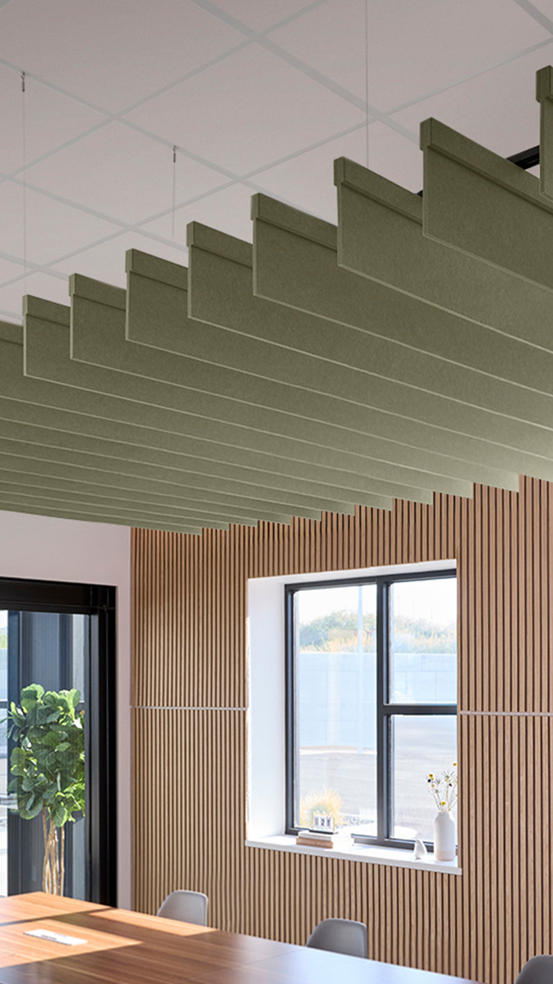 Green acoustic ceiling blade baffles suspended from the ceiling, installed in a conference room. Felt Right's acoustic blade baffles absorb 65% of sound waves, making office spaces quieter and feel more calm.