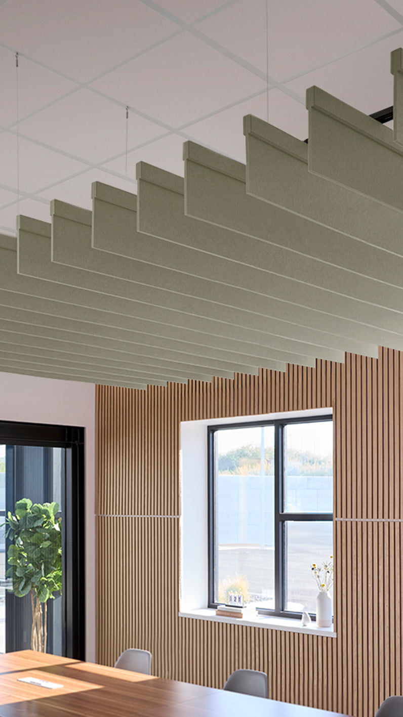 Soft green acoustic ceiling blade baffles suspended from the ceiling, installed in a conference room. Felt Right's acoustic blade baffles absorb 65% of sound waves, making office spaces quieter and feel more calm.