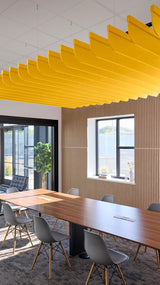 Yellow fin-shaped acoustic baffles suspended from ceiling above conference table in office space.