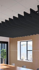 Black curved fin baffles suspended from ceiling in modern interior with wood paneling and windows.