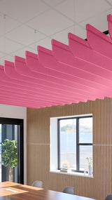 Pink curved acoustic baffles suspended from ceiling in office space with wood wall paneling.