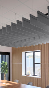 Multiple gray acoustic blade baffles suspended from ceiling grid in modern office space with wood wall paneling.