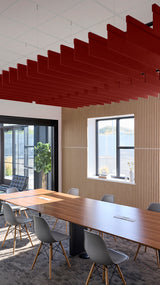 Red straight acoustic blade baffles suspended from ceiling in modern office conference room with wood table and chairs.