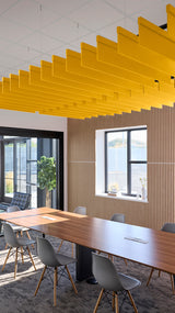 Yellow straight acoustic blade baffles suspended from ceiling in modern office conference room.