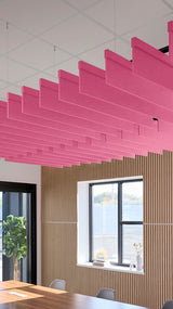Pink straight acoustic blade baffles suspended from ceiling in office space above wooden wall paneling.