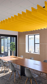 Yellow straight acoustic blade baffles suspended from ceiling in modern office meeting room with conference table.