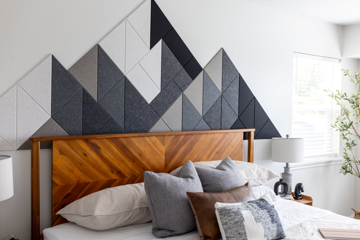 Warm Shaded Mountain Felt Right design above a wooden headboard and bed with white comforter and grey and brown pillows.