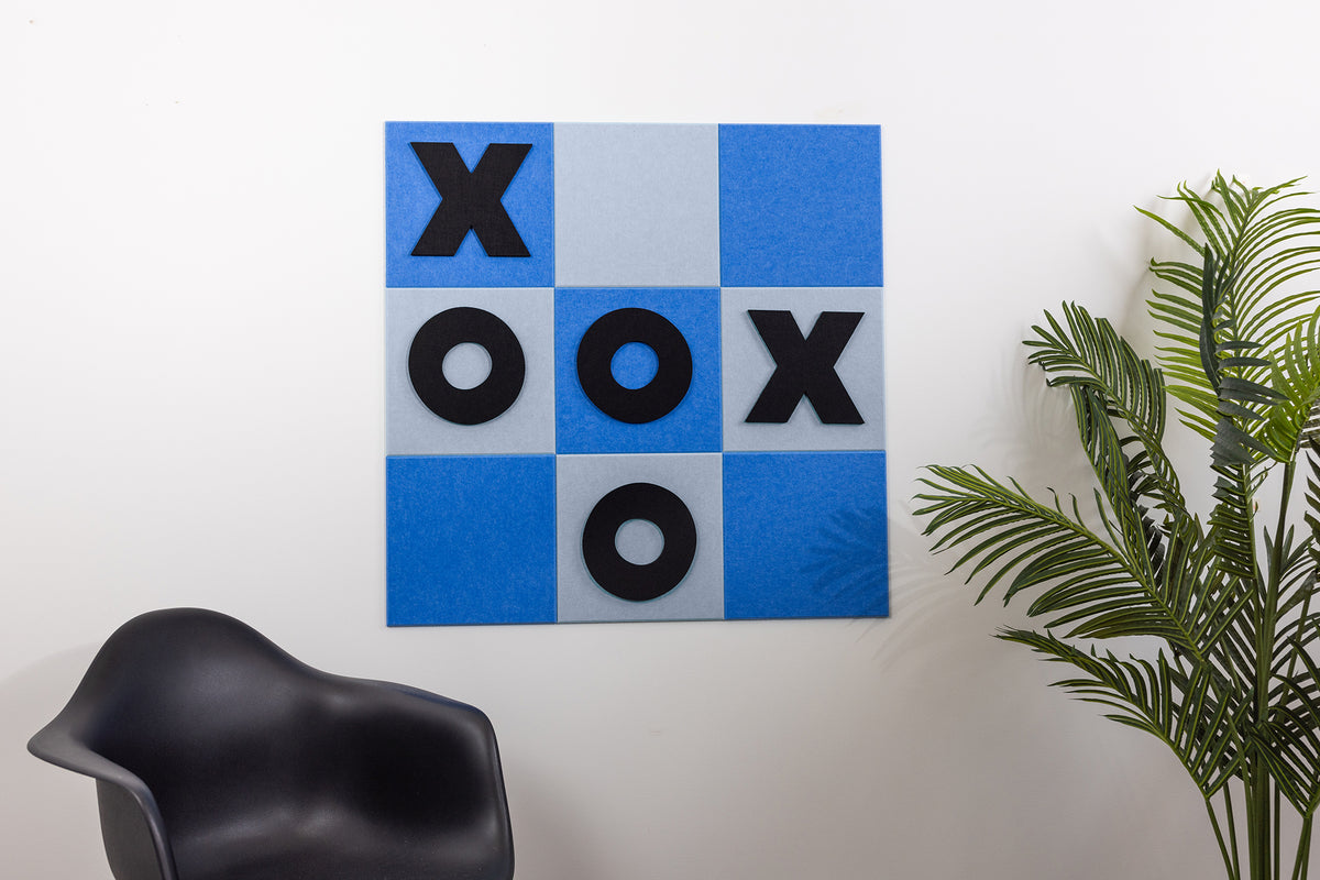 Wall-mounted tic-tac-toe game board with blue and gray squares displaying X and O pieces in play.