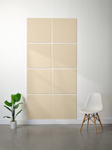 Beige acoustic panels on a wall with a white chair and plant in a minimalistic room.