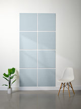 Wall with acoustic panels and a white chair on a gray floor