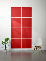 Red wall panels with geometric patterns on a white wall, with a plant and chair in the foreground.