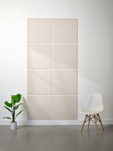 Beige acoustic panels on a wall with a white chair and plant in a minimalistic room.