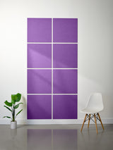 Purple square wall art panels on a white wall with a plant and chair in the foreground.