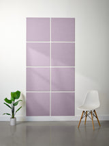 Purple acoustic panels on a wall with a white chair and plant in a minimalistic room.