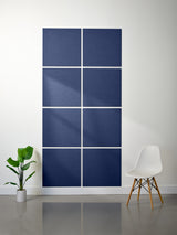Blue wall panels on a white wall with a plant and chair in the foreground
