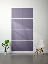 Purple acoustic panels on a white wall with a plant and chair in the foreground.